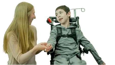 Smiling child in a wheelchair wearing a black t-shirt, looking at the camera