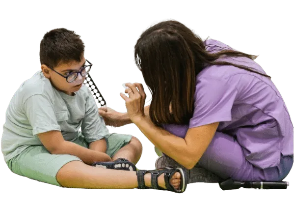 Woman supporting a child during a physiotherapy session in a home setting. gross motor skills