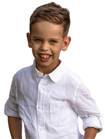Smiling child in a white shirt looking at the camera, genetic conditions
