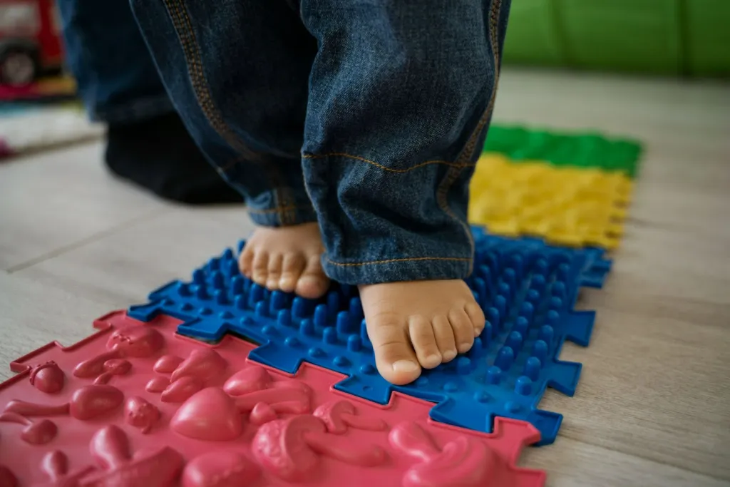 Child using sensory mat in movement therapy for coordination and balance exercises