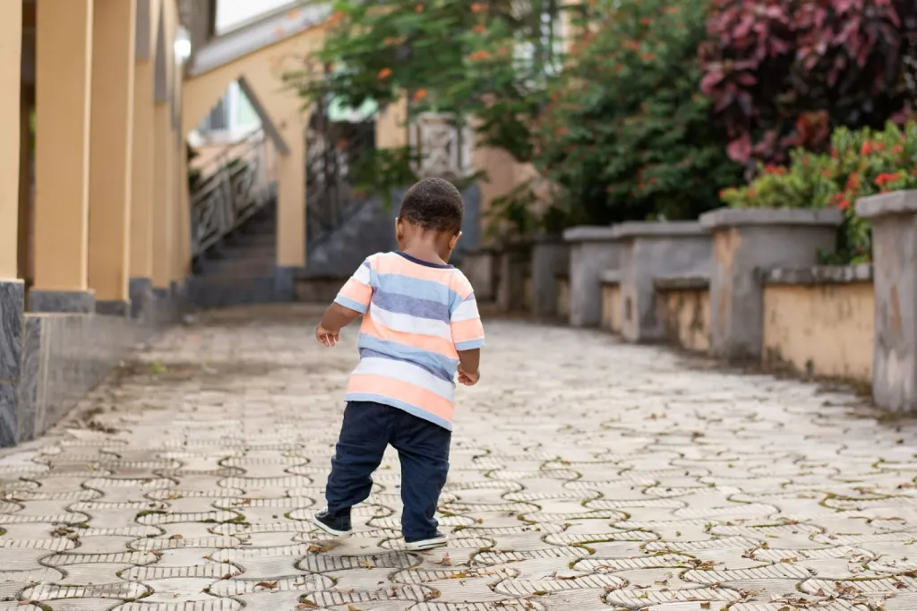 Assessing a child walking on toes during an outdoor physiotherapy session