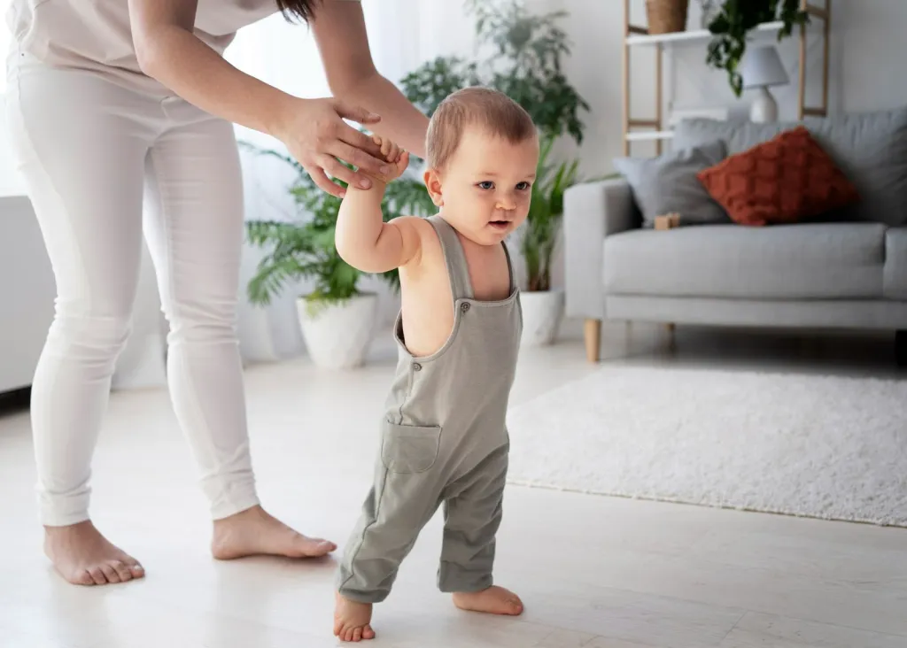 Baby taking first supported steps with parent, showing when babies start walking and learning to walk independently