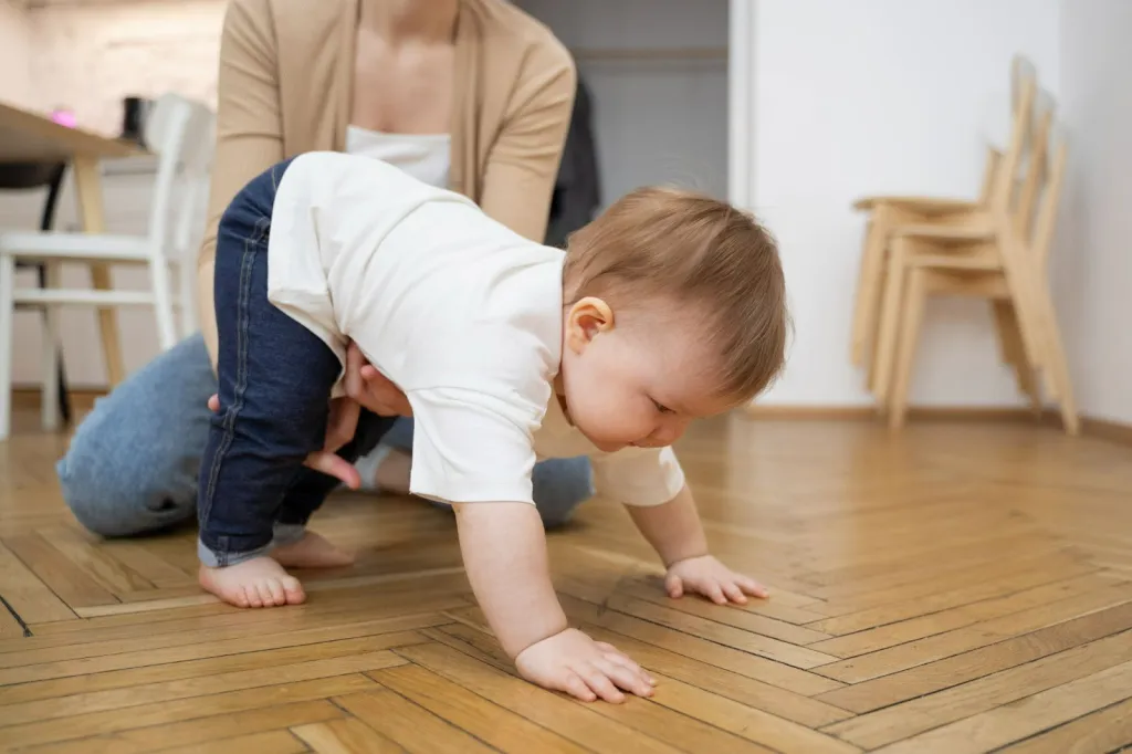 Parent helping baby practise standing, building strength and balance before walking, related to when babies start walking