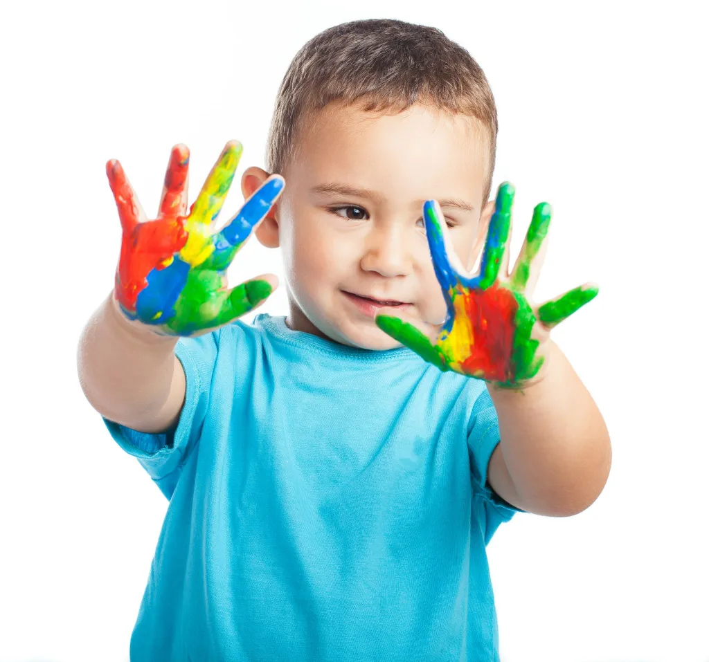 Child engaged in sensory play with finger painting as part of developmental delay therapy for creativity and coordination