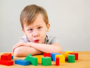 Child exploring colourful building blocks during developmental delay therapy to improve problem-solving and focus