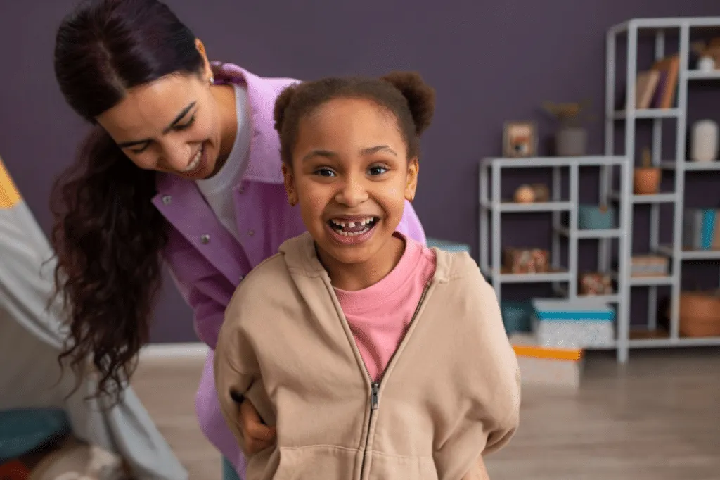 Child smiling during play-based session at paediatric physical therapy clinic