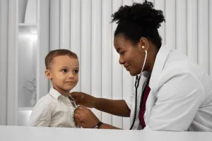 Child in mask attending session at paediatric physical therapy clinic