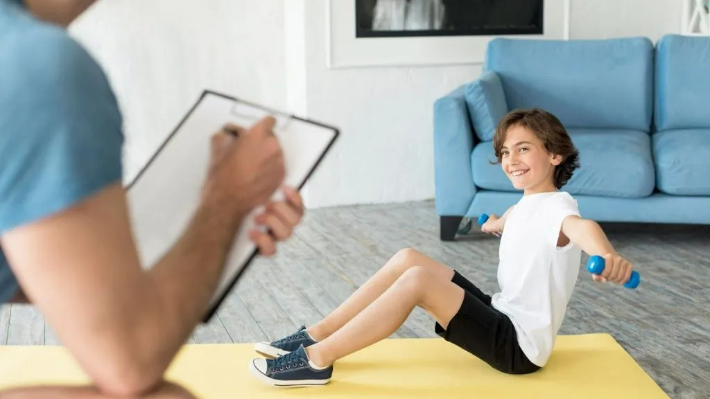 Physiotherapist guiding a child’s exercise routine at home as part of a home visit physio Sydney program