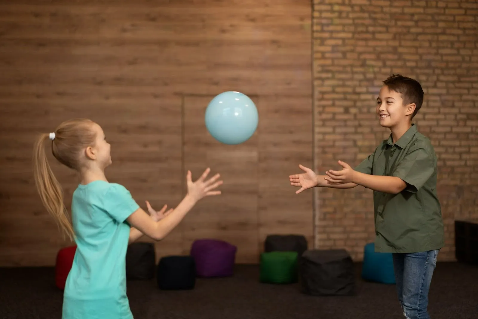 Children practising ball-catching to improve coordination and movement skills in therapy for poor coordination in child